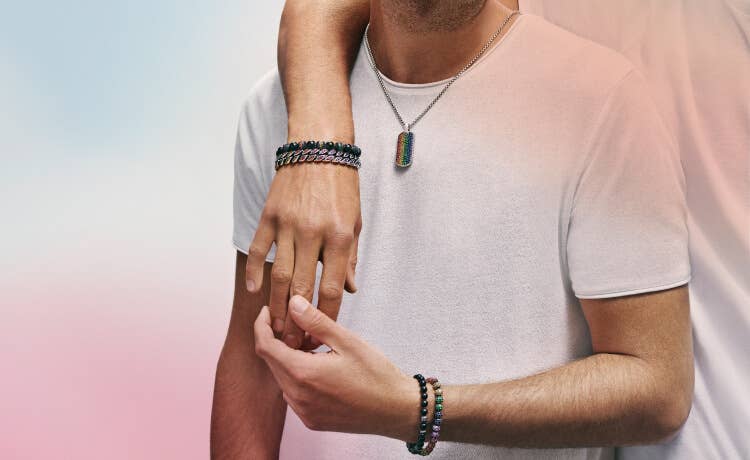 An image of two men wearing David Yurman pavé rainbow bracelets and tag.
