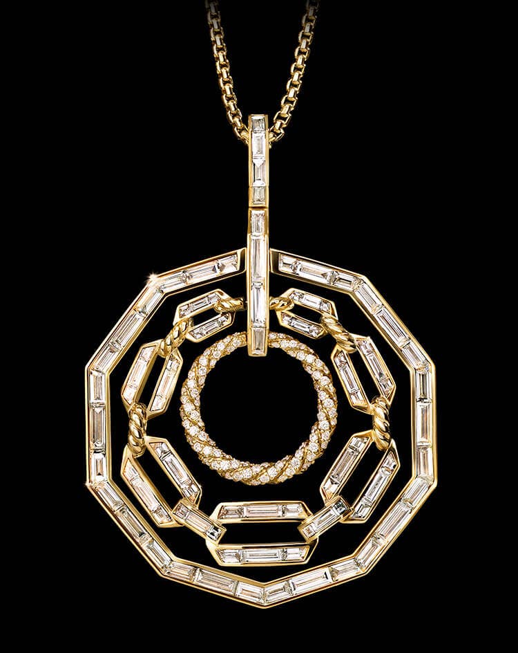 A color photo shows a David Yurman High Jewelry Stax three-loop pendant necklace against a black background. The jewelry is crafted from 18K yellow gold and is fully set with brilliant-, baguette- and custom-cut white diamonds.