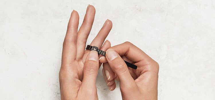 A finger being measured with a ring sizer.