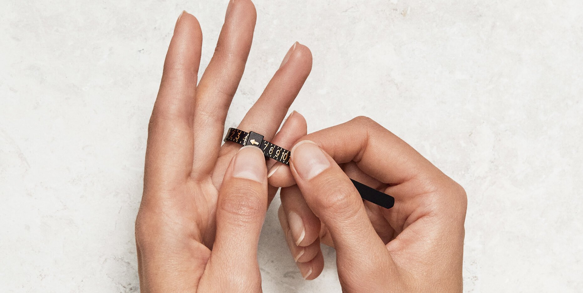 Hands holding a David Yurman ring sizer.