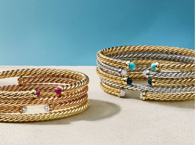 A collection of Petite Cable Bracelets in different metals with a variety of stones.