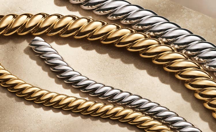 An image of 4 sculpted cable bracelets in silver and yellow gold.
