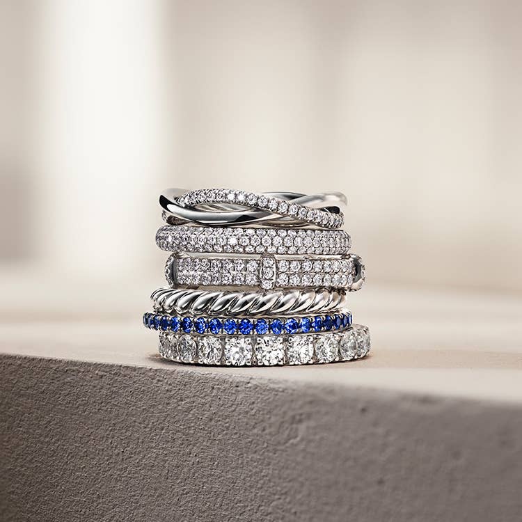 An image of six platinum wedding bands stacked on top of eachother.