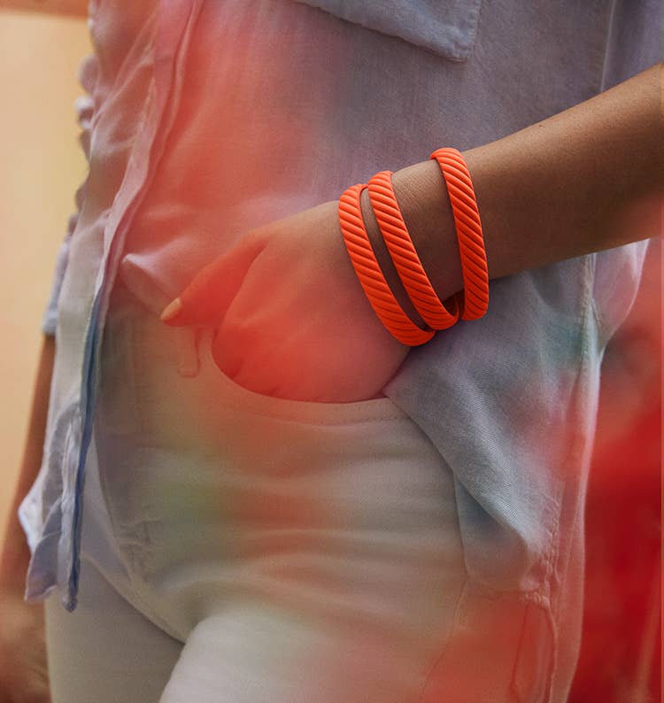 An image of a model wearing the orange rubber bracelets.
