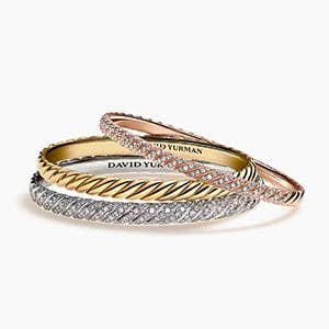 A stack of gold and silver David Yurman women's bangle bracelets with and without diamonds.