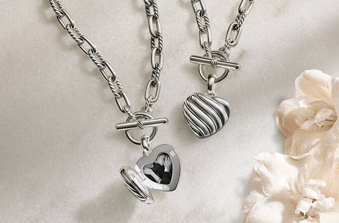 Two David Yurman heart pendants in silver.