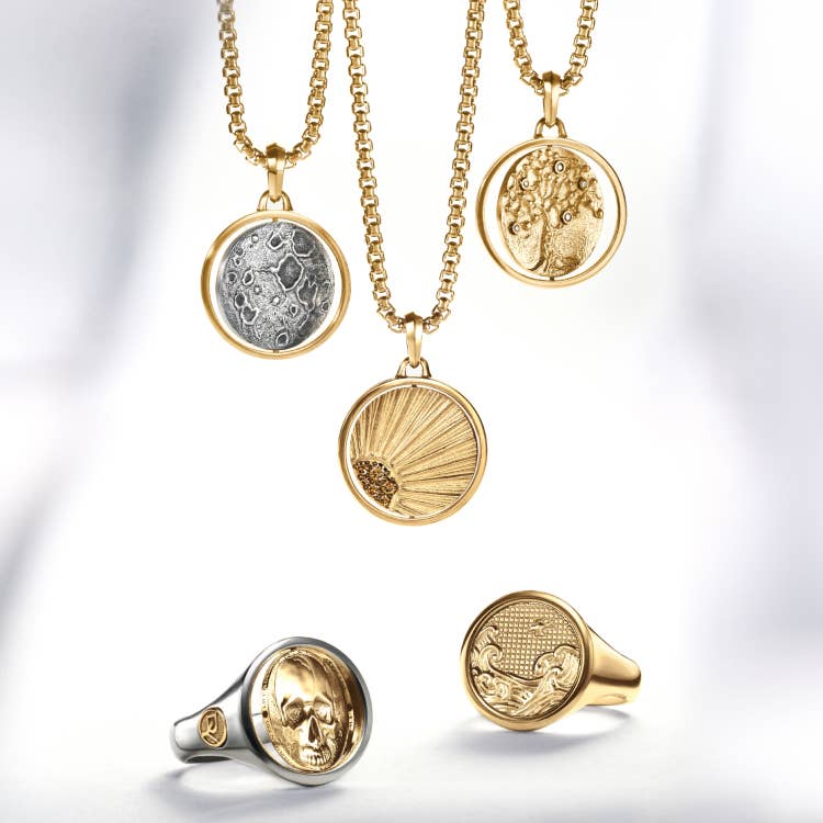 An image of David Yurman rings and amulets in gold.