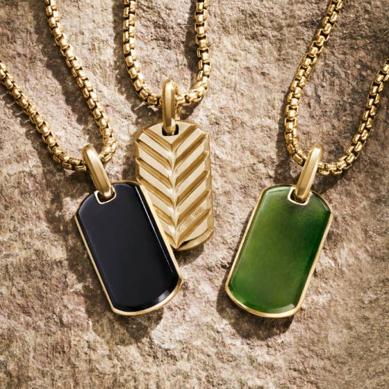 Three David Yurman tags on gold chains.