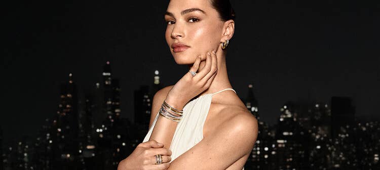 A model stacking David Yurman bracelets.