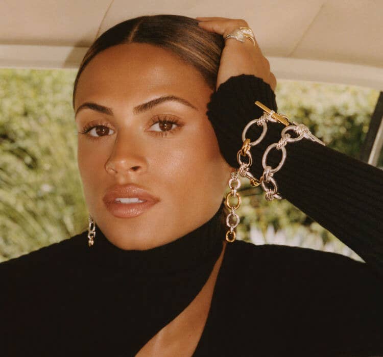 An image of Sydney wearing DY Mercer bracelets and earrings.
