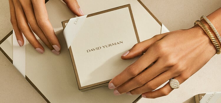 Hands holding David Yurman gift packaging.