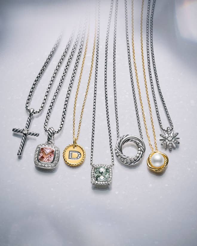 A variety of David Yurman chains with charms and amulets.