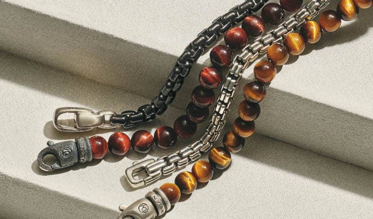 An image of four bead and chain bracelets for men.