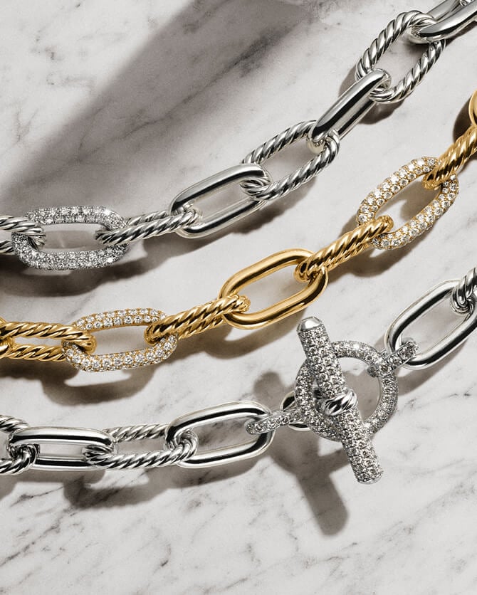 Three David Yurman chains in gold and silver.