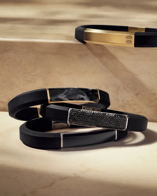 A collection of 4 David Yurman rubber bracelets with gold, silver and stones.