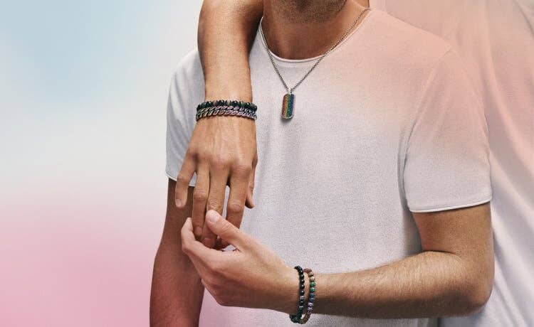 An image of two men wearing David Yurman pavé rainbow bracelets and tag.