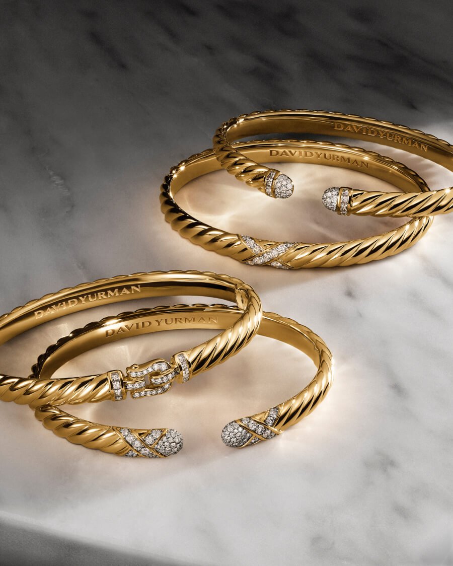 Four David Yurman bracelets in gold.