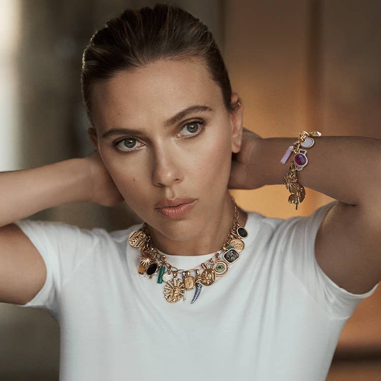 An image of Scarlett Johansson wearing a chain necklace and bracelet filled with amulets.