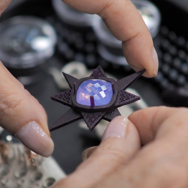 An image of a purple gemstone in a star shape.