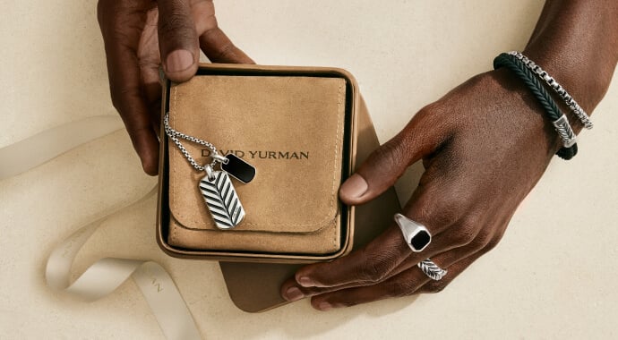 A man's hands wearing David Yurman jewelry.