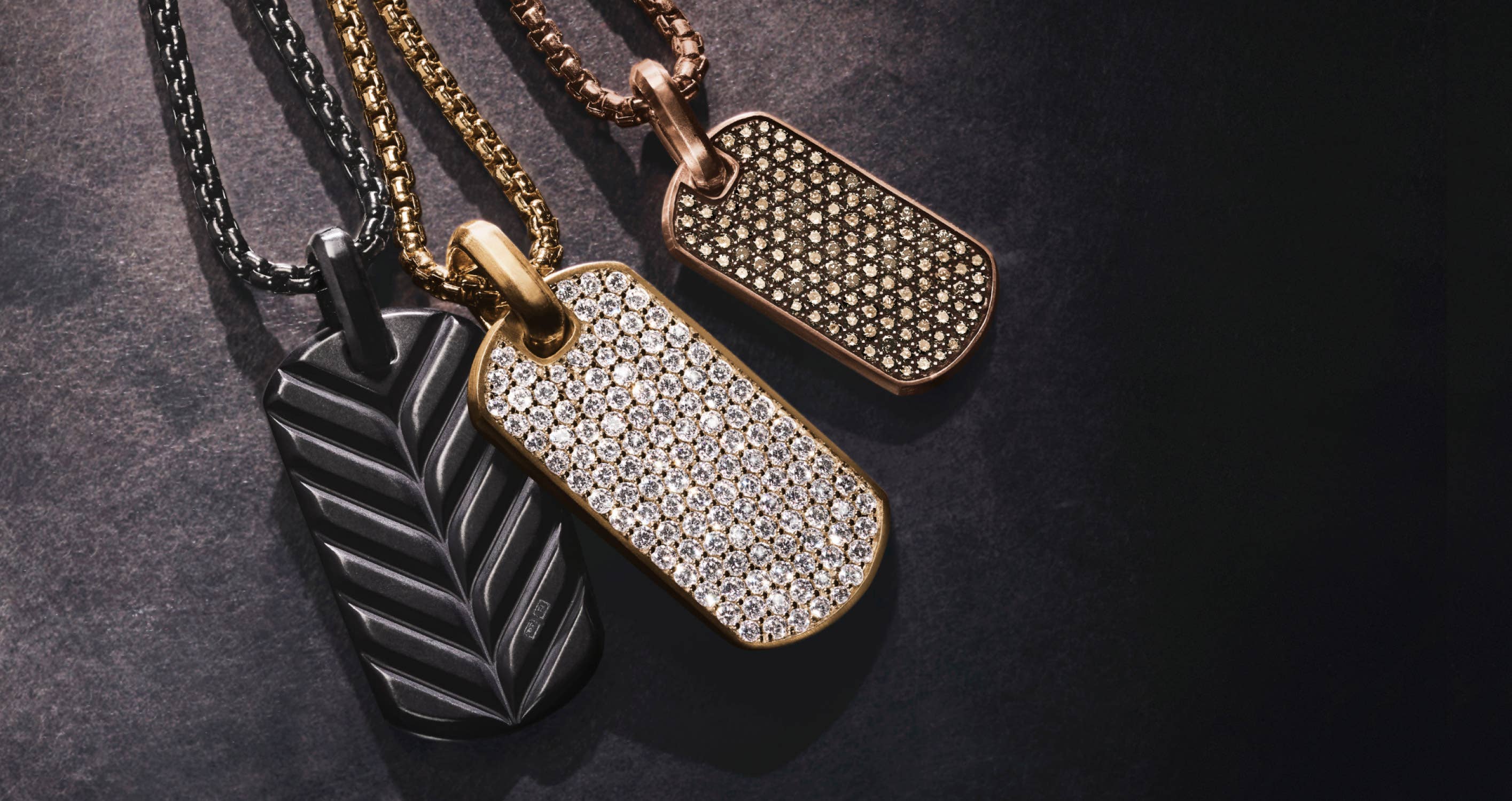 Men's Gift Guide: Three different men's tags, one black, one gold with diamonds and one gold with stones.