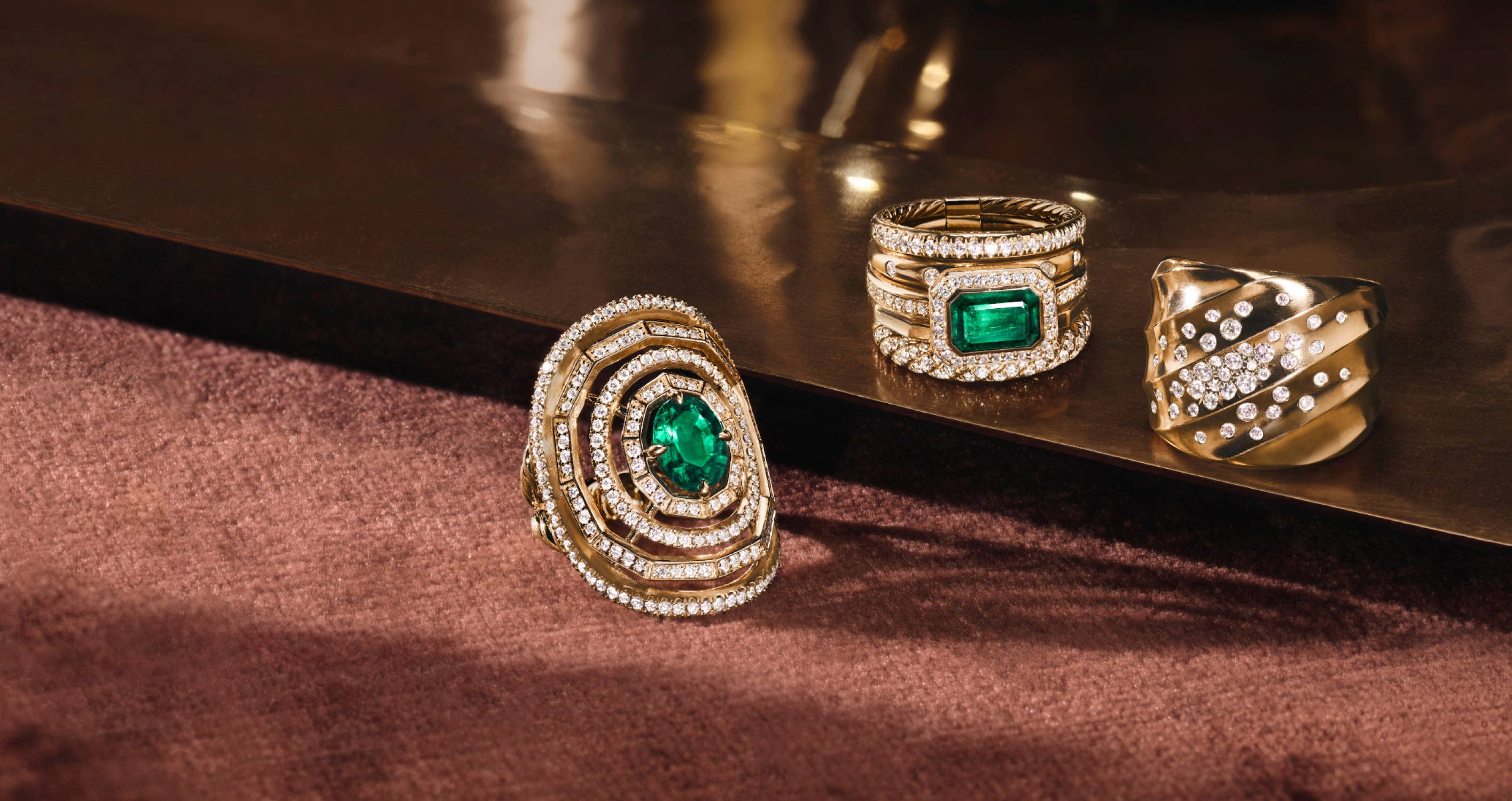 Gift Guide for her - Modern David Yurman gold rings with emerald and diamond stones.