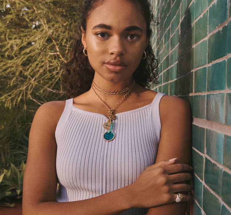 An image of Chandler Kinney wearing gold chain and multiple amulets.