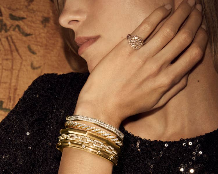 An image of Scarlett wearing a stack of gold bracelets.