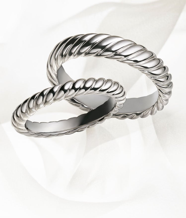 An image of two platinum cable David Yurman band rings.