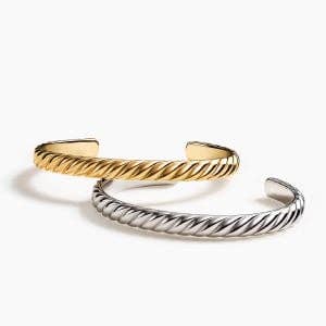 One gold and one silver David Yurman Sculpted Cable cuff bracelet.