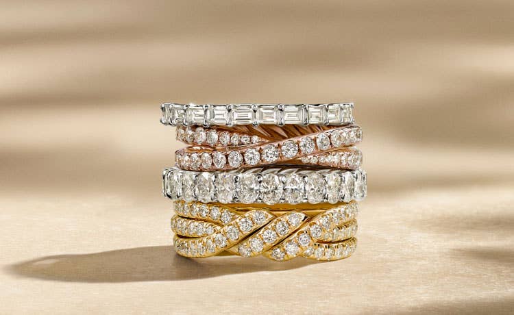 An image of four wedding bands stacked on top of eachother.