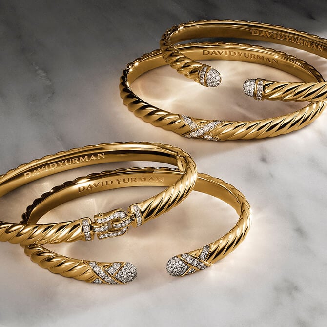 Four David Yurman Sculpted Cable bracelets in gold.