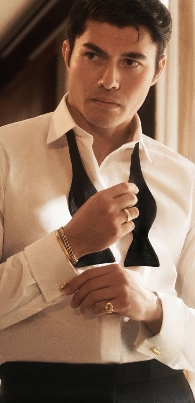 Henry Golding wearing David Yurman bracelet and rings.