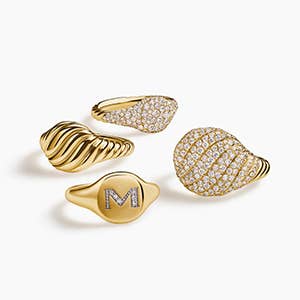 Four David Yurman pinky rings in gold with and without stones.