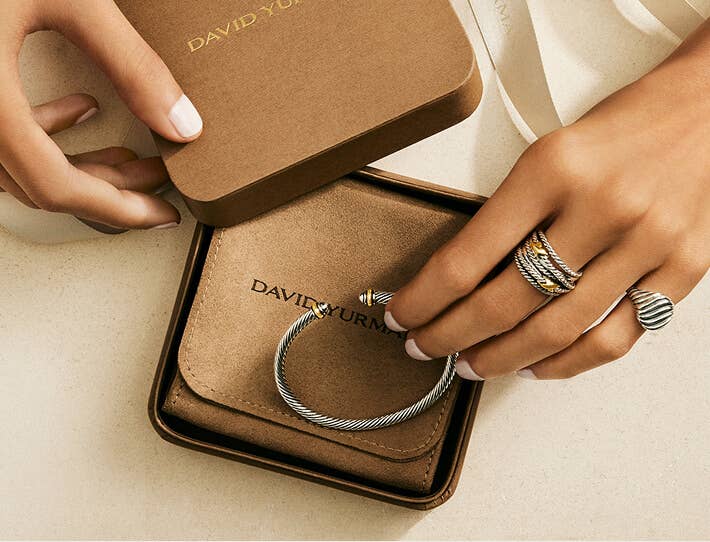 David Yurman bracelet in a gift box with a hand wearing rings.