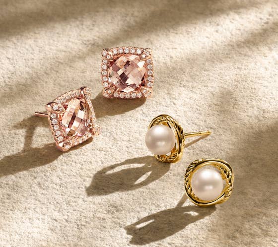 Two pairs of gold David Yurman earrings. One with pearls and cable detail, and one with pink stones and diamonds.