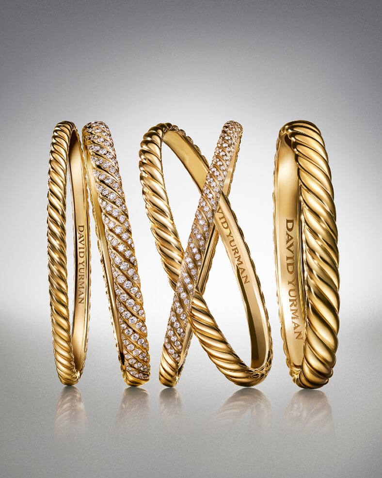 Five David Yurman Sculpted Cable bracelets in gold.