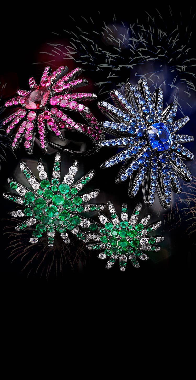 An image shows a David Yurman High Jewelry Starburst pendant, ring and pair of earrings clustered together against a black background. The jewelry is crafted from 18K white gold with or without emeralds, diamonds, blue sapphires, pink sapphires or rubies. 