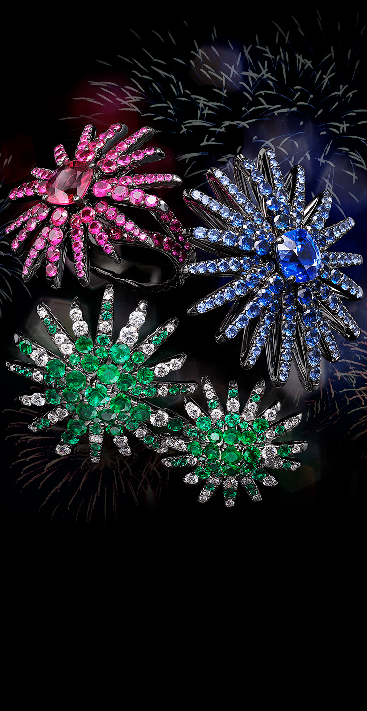 An image shows a David Yurman High Jewelry Starburst pendant, ring and pair of earrings clustered together against a black background. The jewelry is crafted from 18K white gold with or without emeralds, diamonds, blue sapphires, pink sapphires or rubies. 