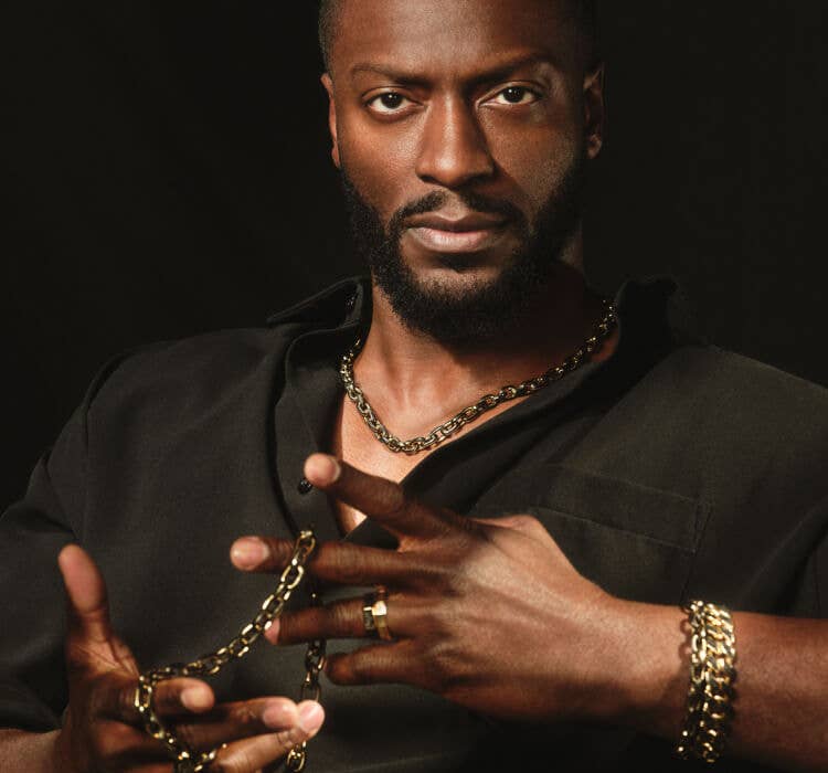 An image of Aldis Hodge wearing Forged Carbon bracelets and necklaces.