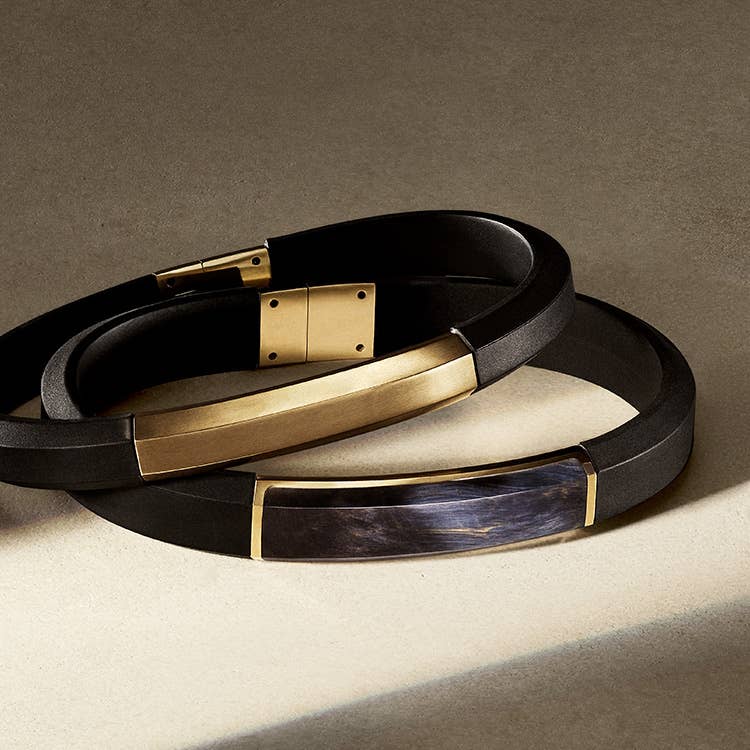 An image of 3 mens rubber bracelets with 18K Yellow gold.