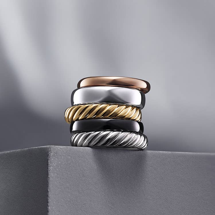 An image of five wedding bands stacked on top of each other.