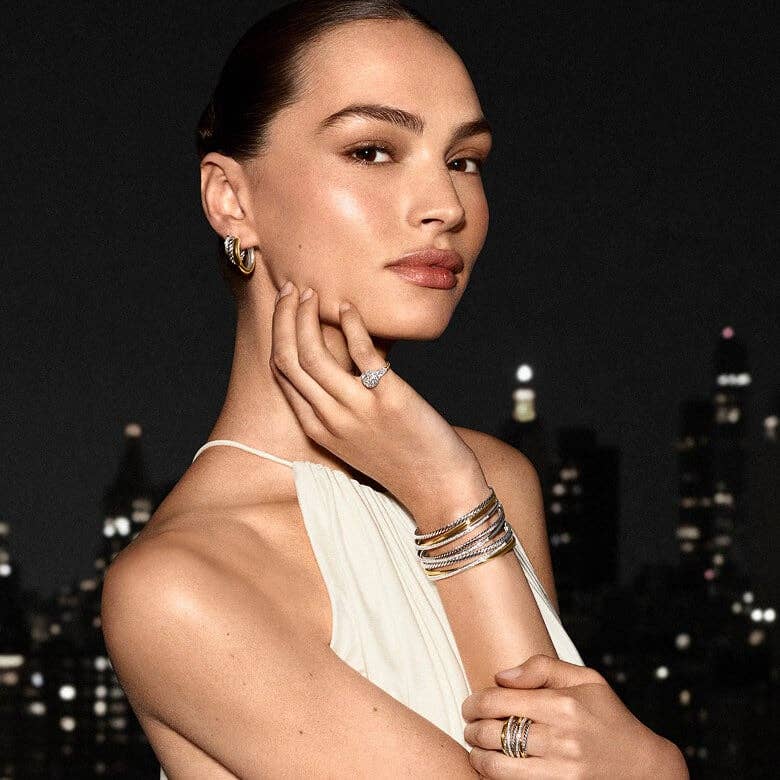 A model wearing stacked bracelets.