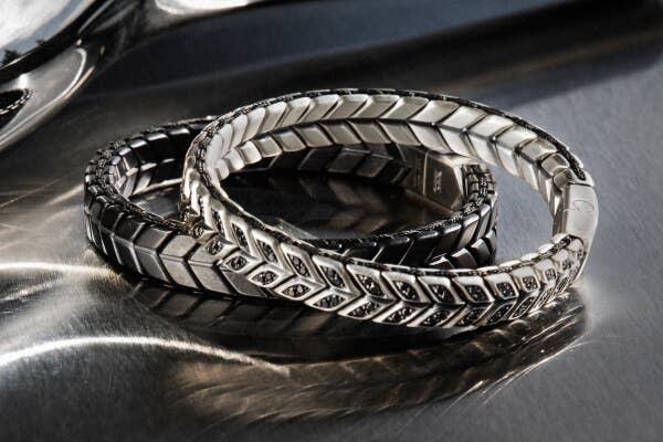 Two David Yurman Men's Chevron Collection bracelets in silver with pave diamonds and black titanium.